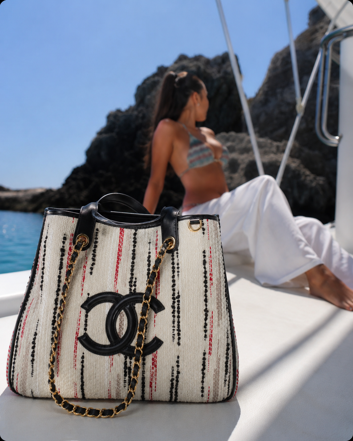 Плетена чанта Chanel на палубата на яхта пред скалист бряг